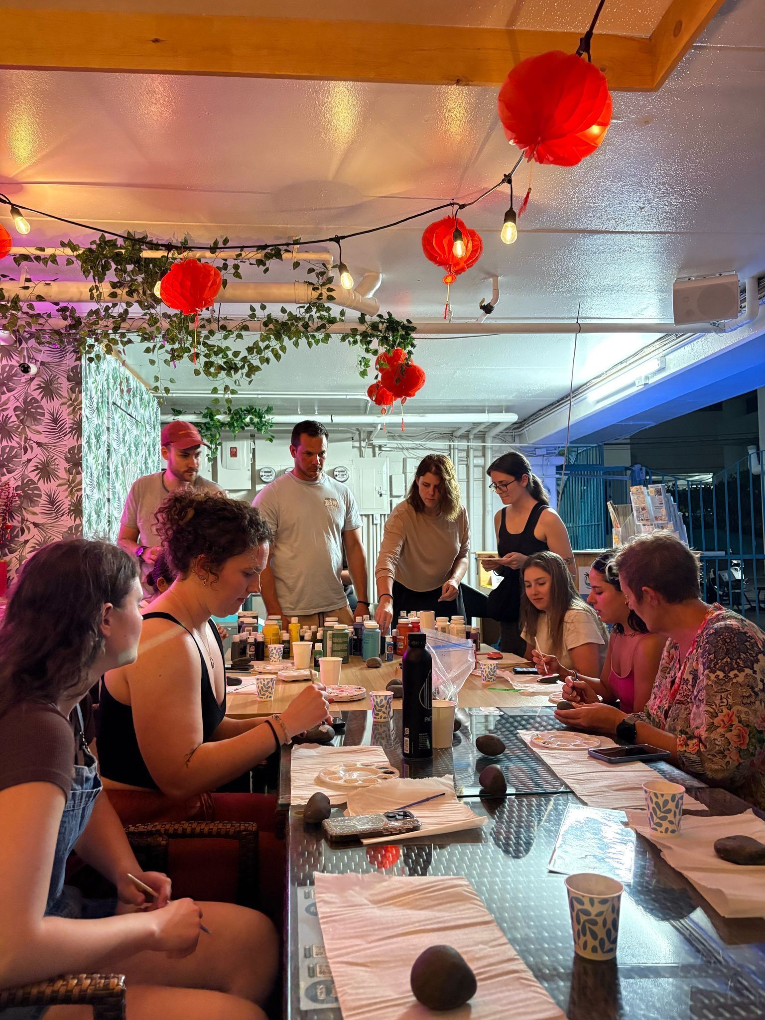 A group of people are sitting around a long table eating food.
