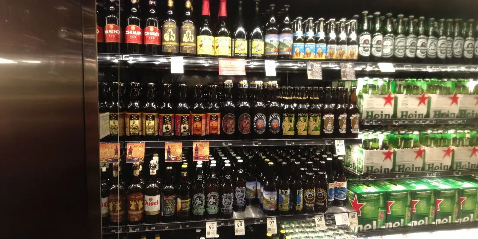 A fridge filled with lots of beer bottles and cans