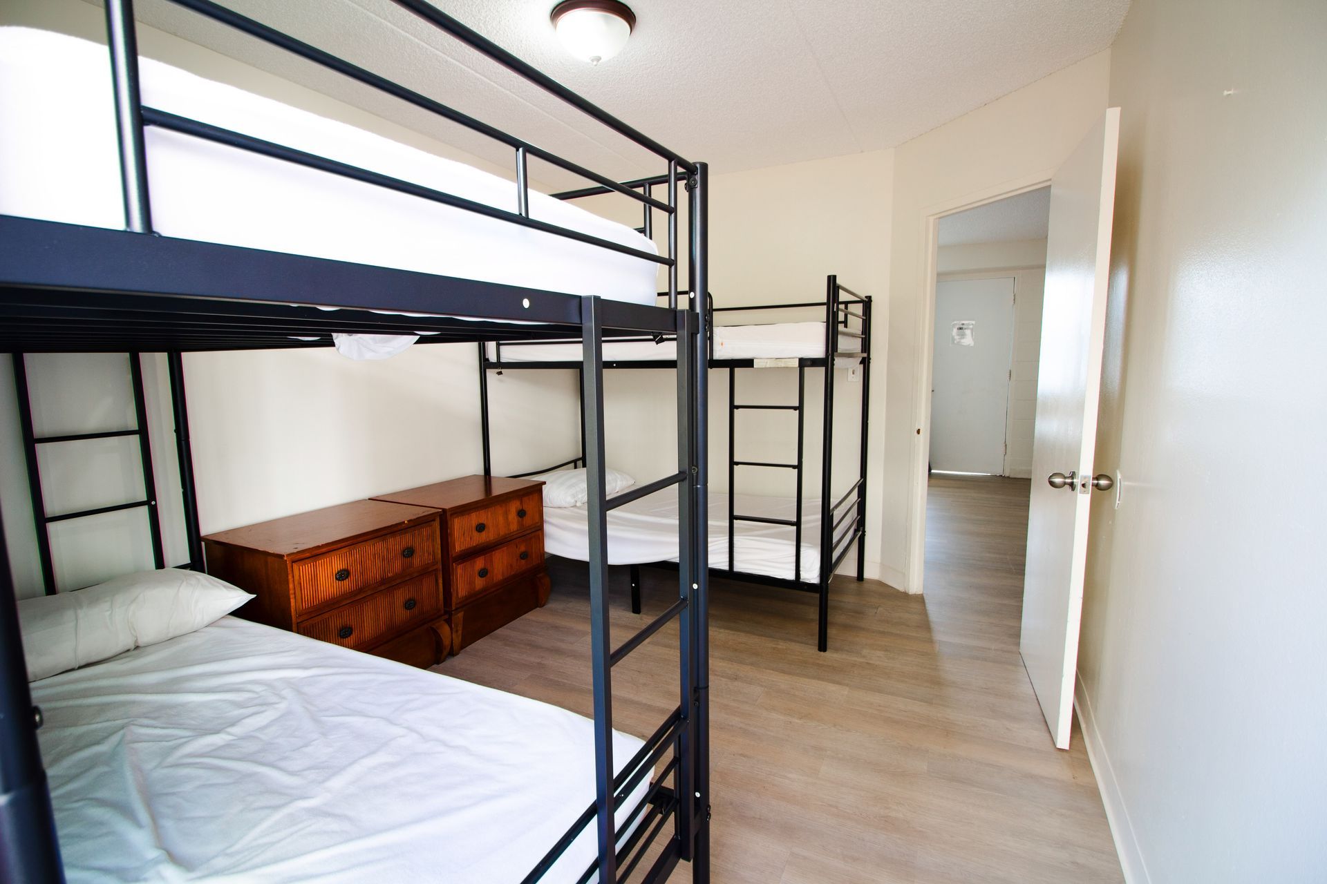 A bedroom with three bunk beds and a dresser