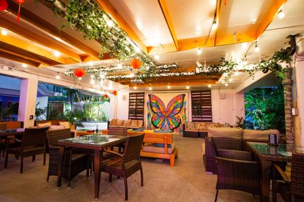 A restaurant with tables and chairs and a butterfly on the wall.