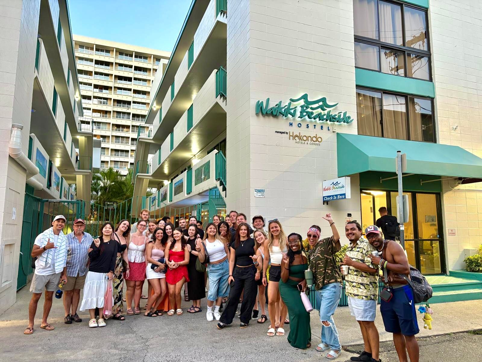 A group of people are posing for a picture in front of a hotel.
