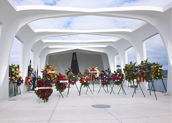 Pearl Harbor Memorial with wreaths, white architecture, and a dark wall.