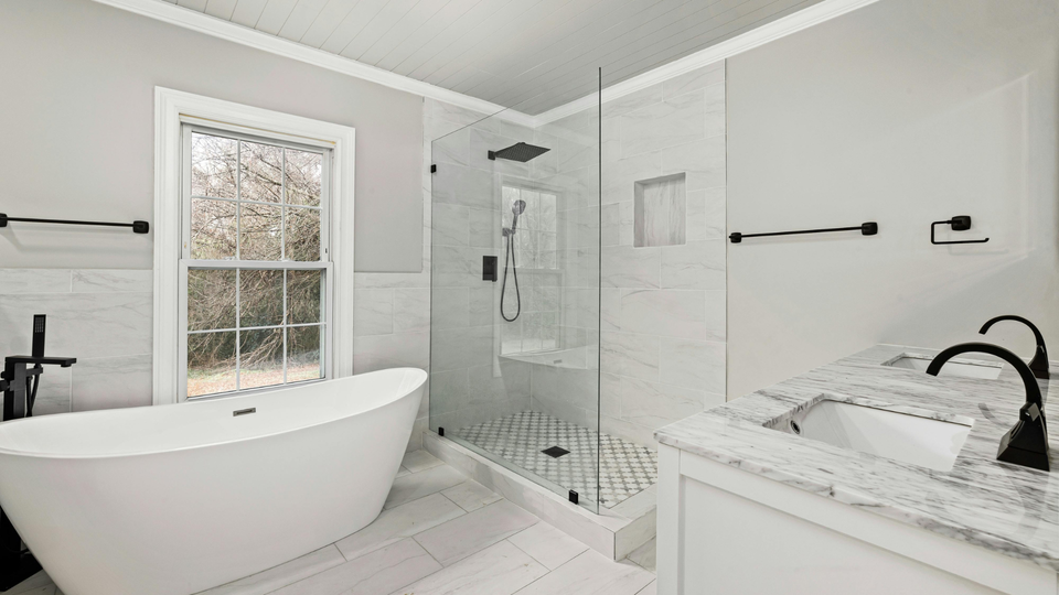 A bathroom with a bathtub , sink , and walk in shower.