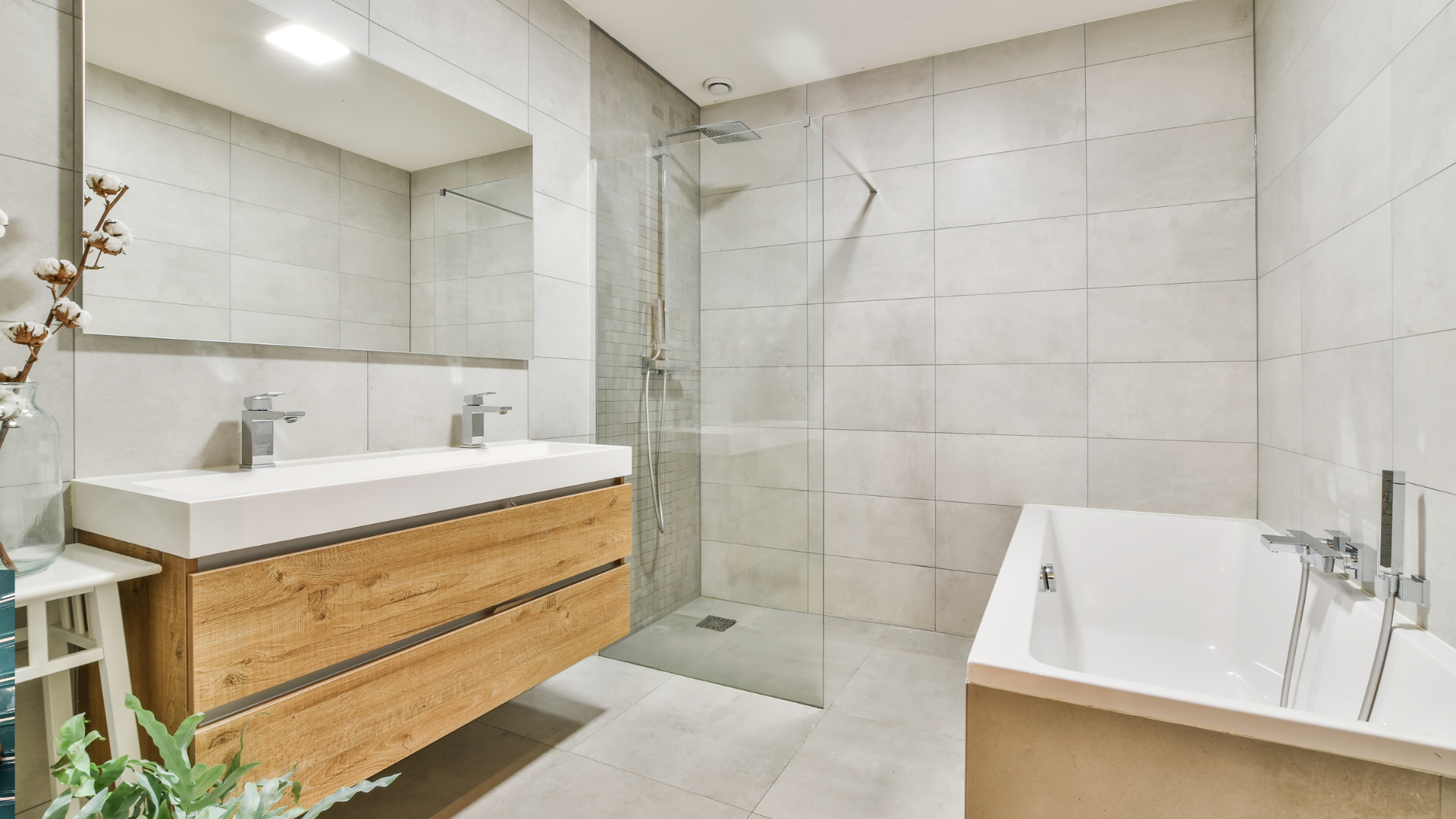 A bathroom with a toilet , sink , mirror and walk in shower.