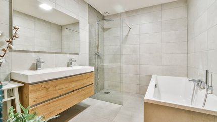A bathroom with a bathtub , sink , mirror and walk in shower.