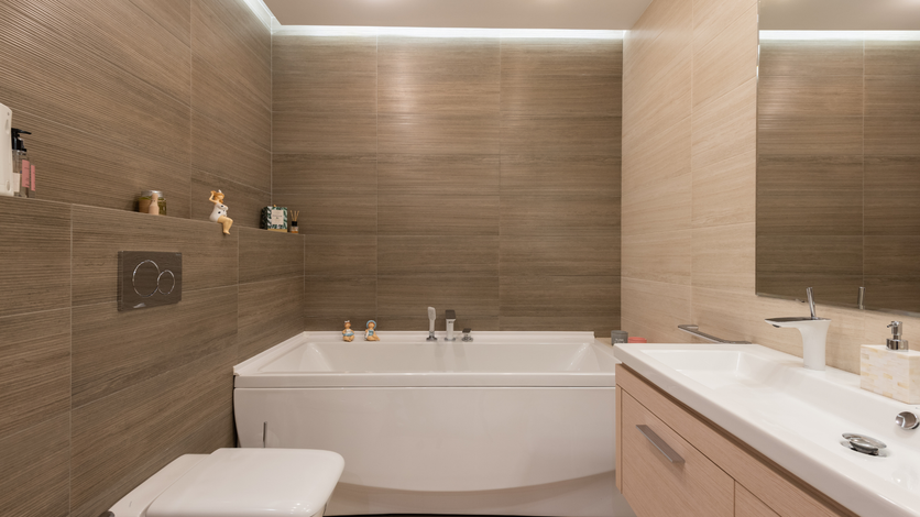 A bathroom with a bathtub , toilet , sink and mirror.