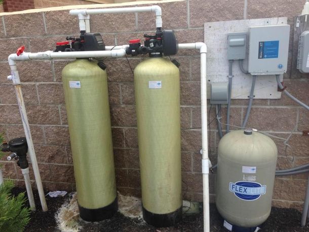 A brick wall with two water tanks and a control box