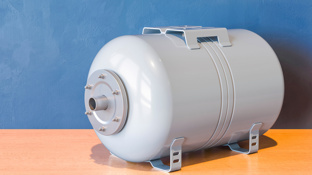 A white water tank is sitting on a wooden table.