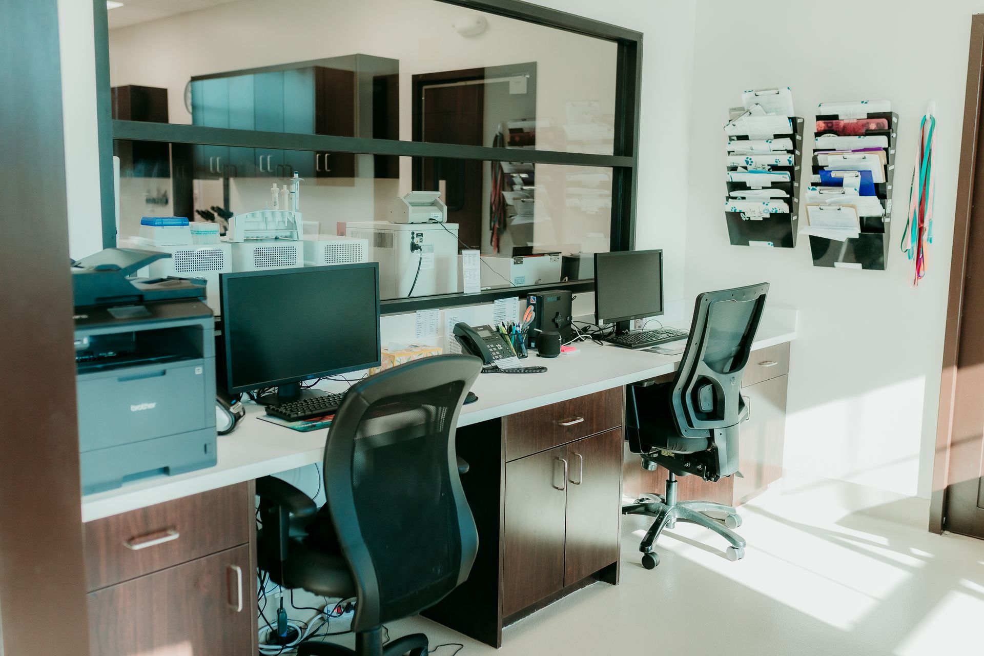 Office space with two computer workstations, a printer, and wall-mounted organizers.