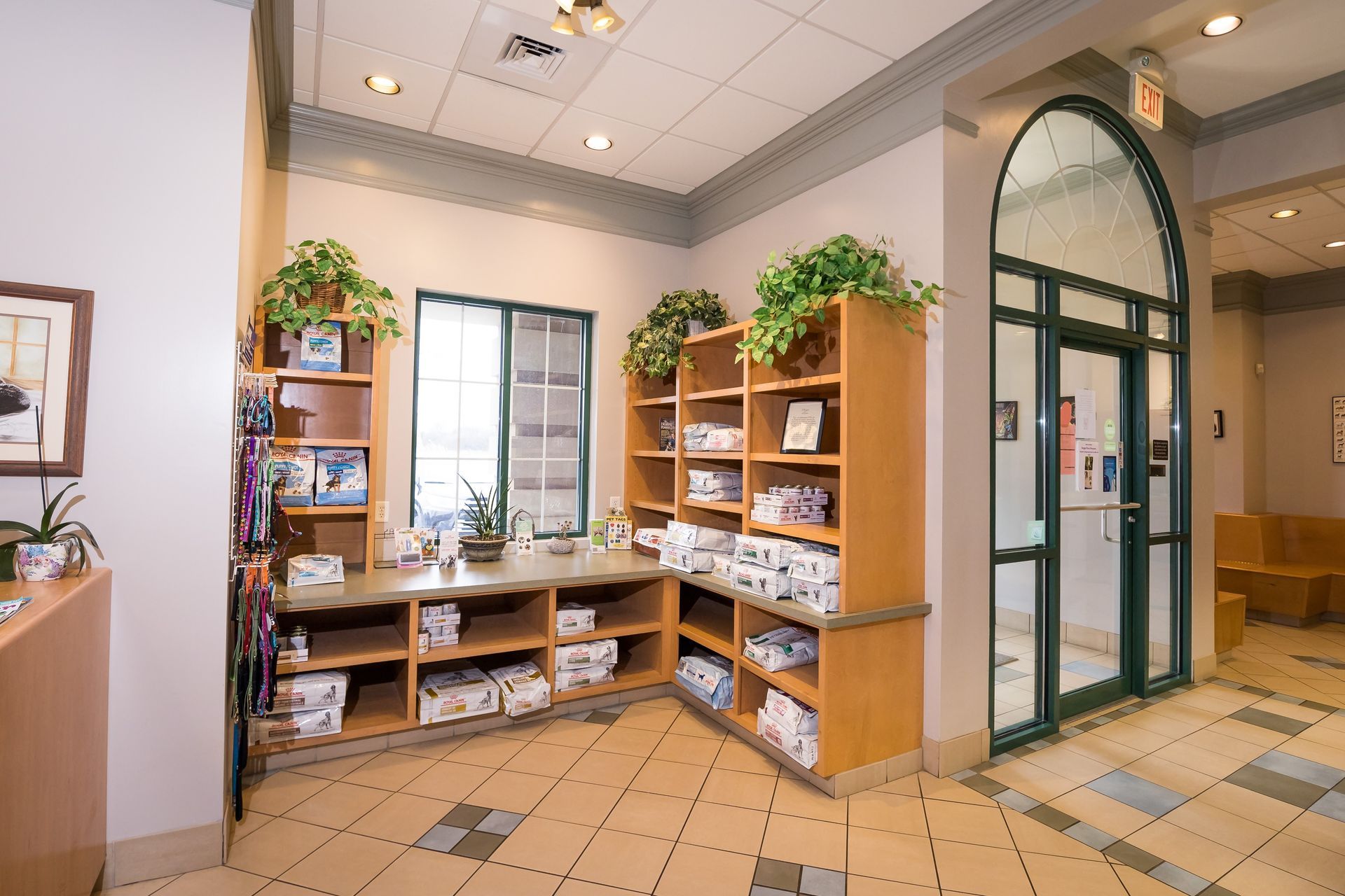 Interior of a pet clinic with shelves displaying products. A glass door is in the background.