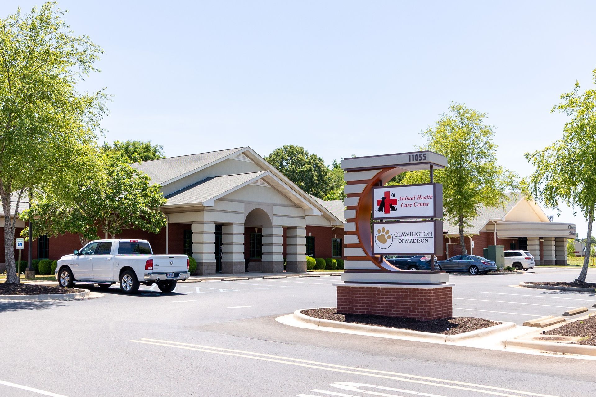Veterinary building with signage; white truck parked in front.