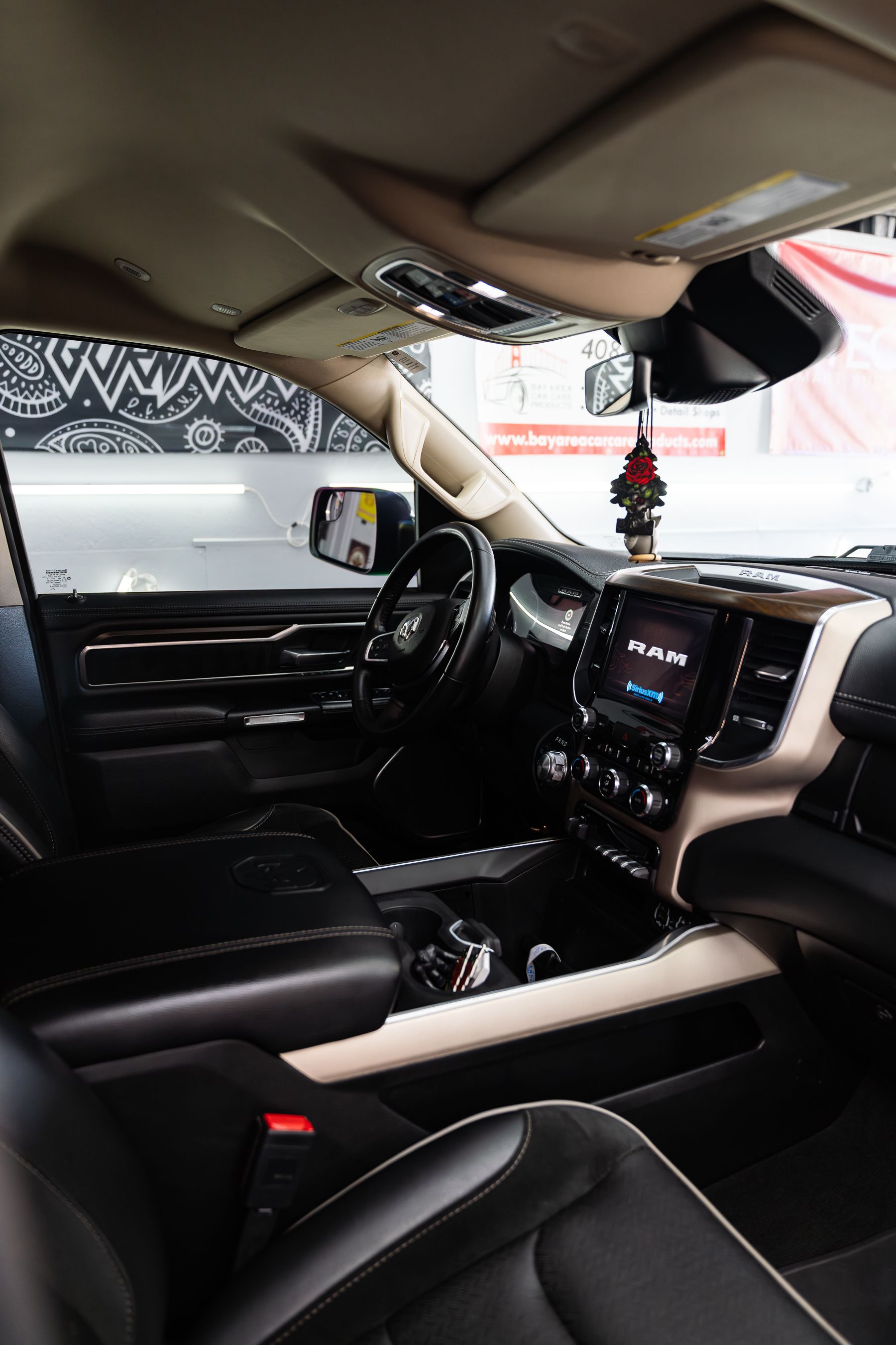 The interior of a modern truck featuring black leather seats, a tan center console, and a digital dashboard display.