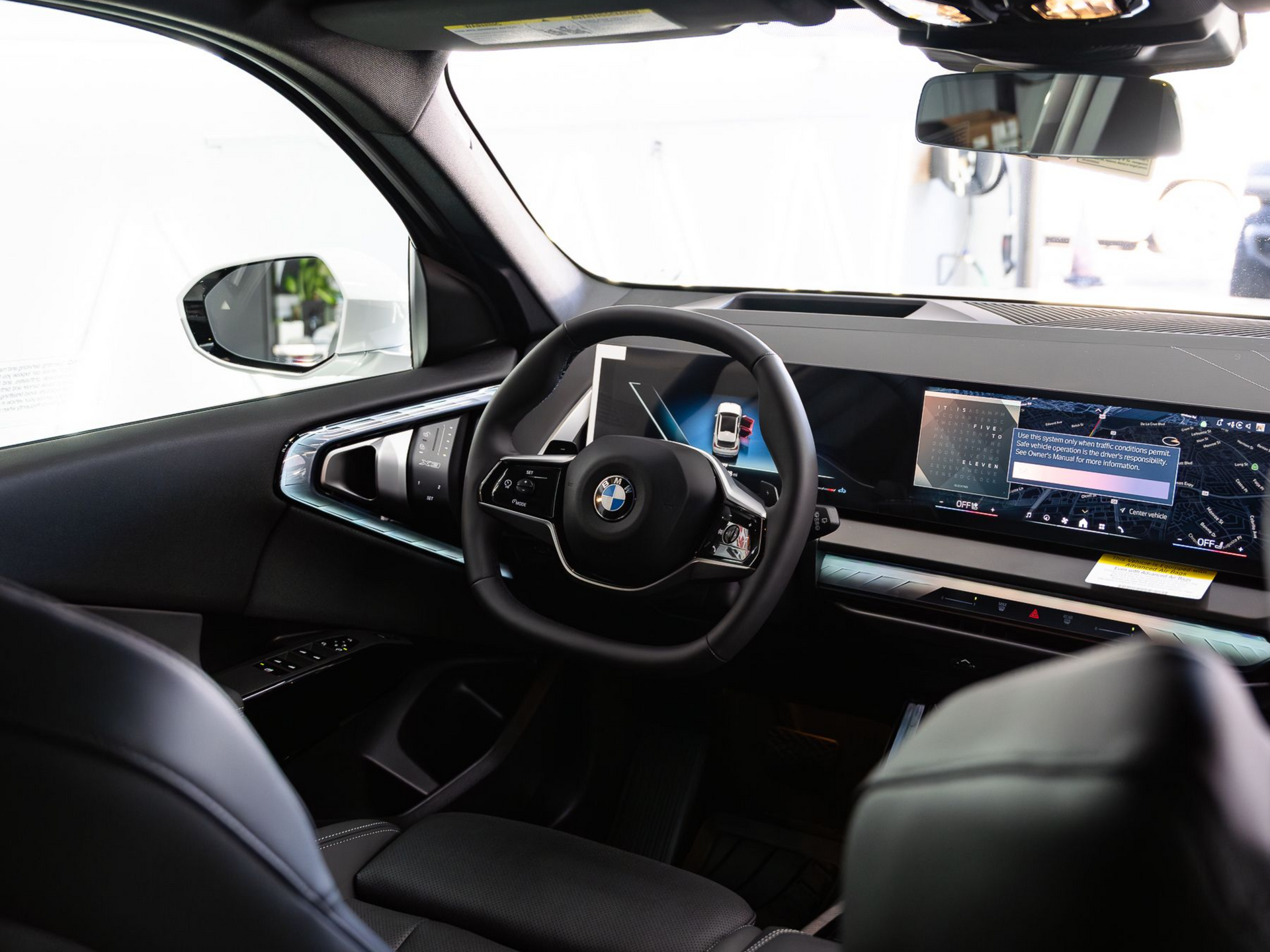 Interior view of an Alpina luxury vehicle with a brown leather dashboard and seats, a black steering wheel, and floor mat.