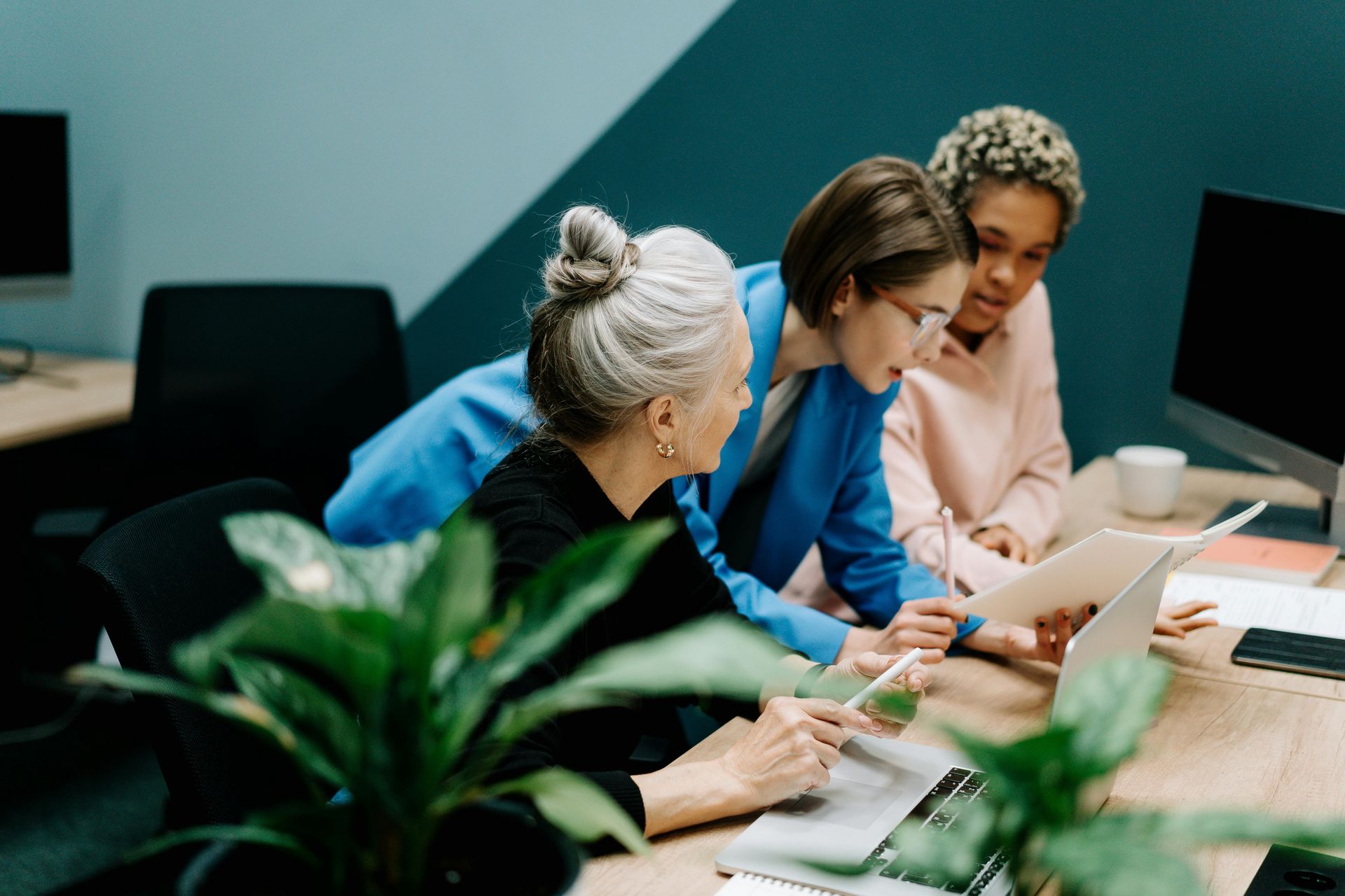 photo graph of 3 ladies looking at a paper report
