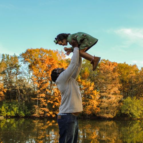 A man is holding a little girl up in the air