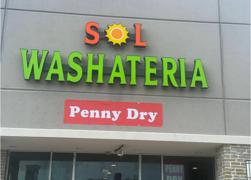 Sign for Sol Washateria, green letters on gray building. Includes 