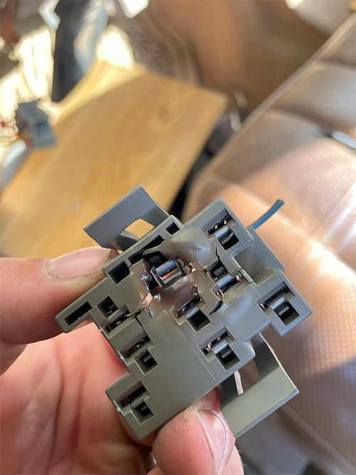 mechanic fixing a melted headlight switch connector on a 1995 Ford F350