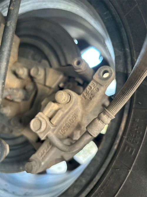 mechanic fixing disk brakes due to a missing caliper bolt