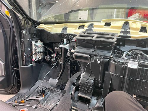 mechanic fixing a heater core on a 2020 ram truck, dash removed