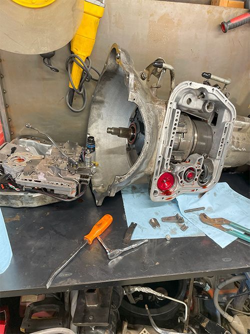 mechanic rebuilding transmission on workbench