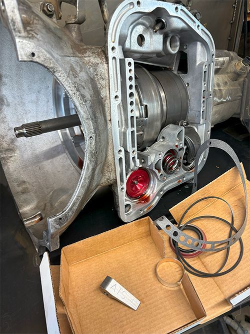 mechanic rebuilding transmission on bench