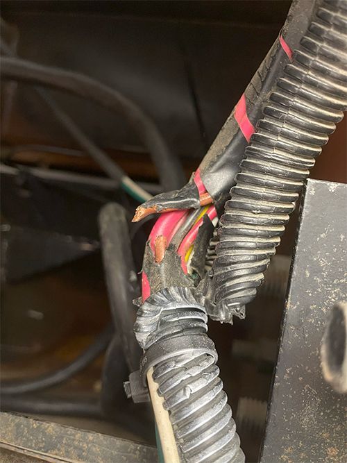 Mechanic fixing a cut 5th wheel wiring harness