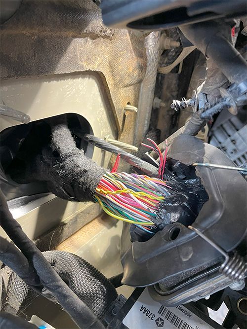 mechanic fixing a cut wiring harness