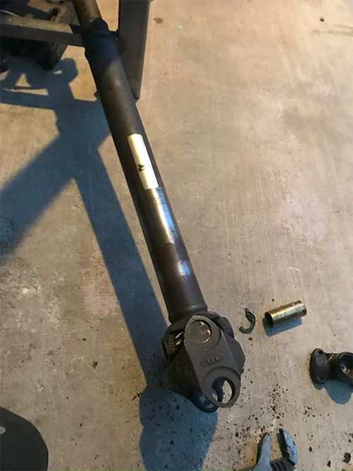 mechanic replacing drivetrain u-joint