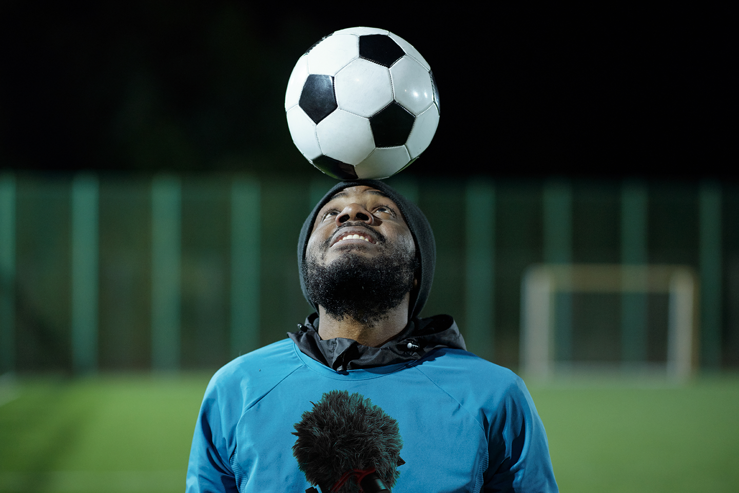 Footballer balances ball on head during interview