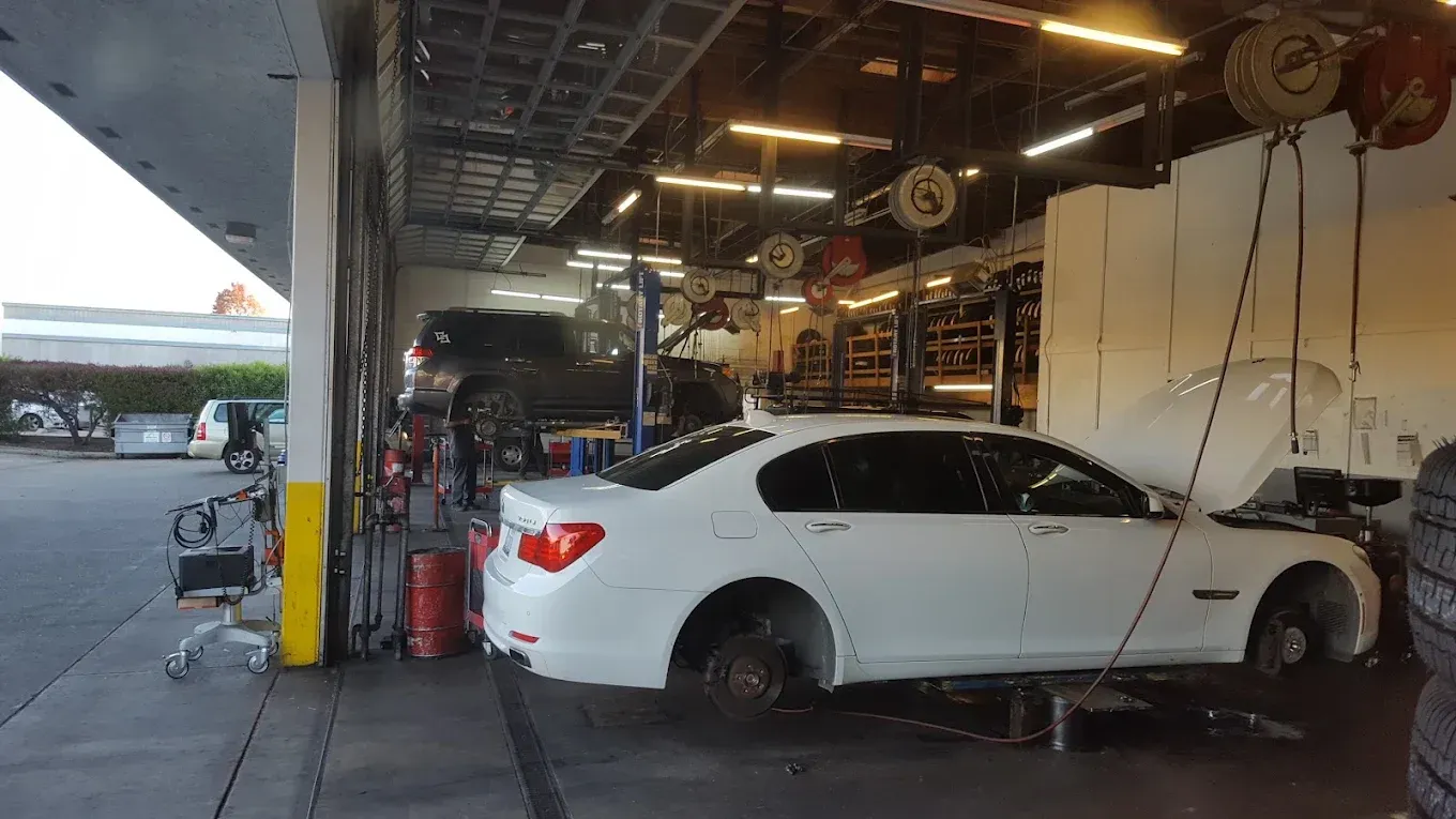 White Sedan Brake Repairs Inside of Auto Shop | Santa Cruz Tire and Auto Care
