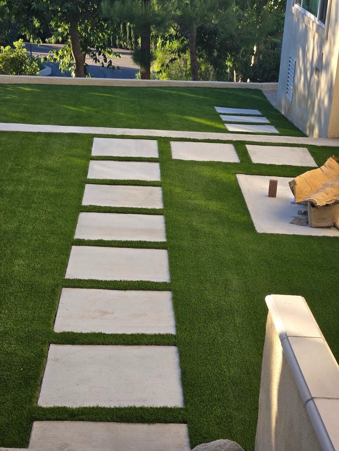 A lawn with a row of concrete walkways leading to it.