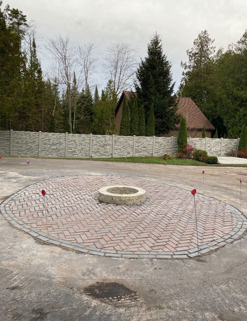 There is a fire pit in the middle of a brick circle.