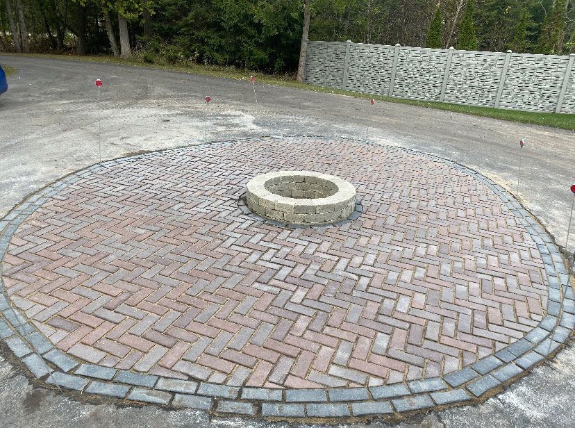 A fire pit is surrounded by bricks in a circular pattern.