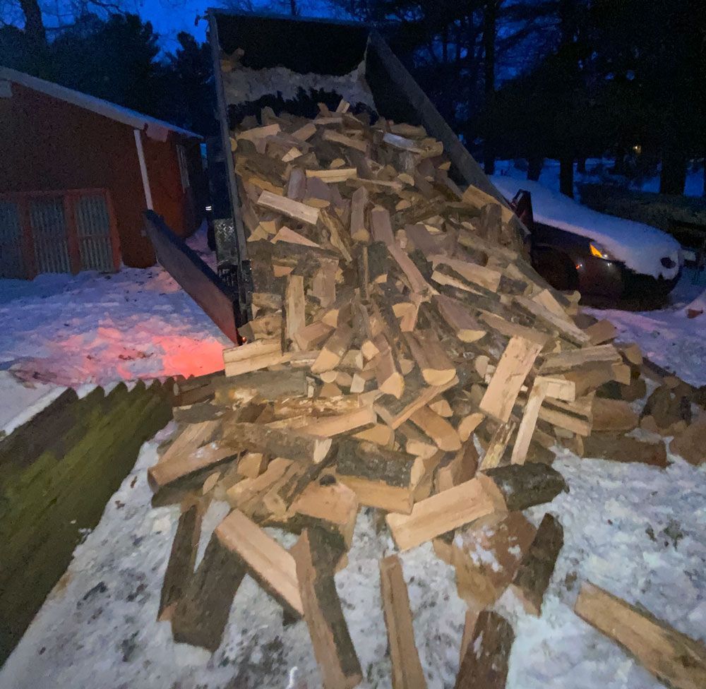 A pile of wood is being loaded into a truck
