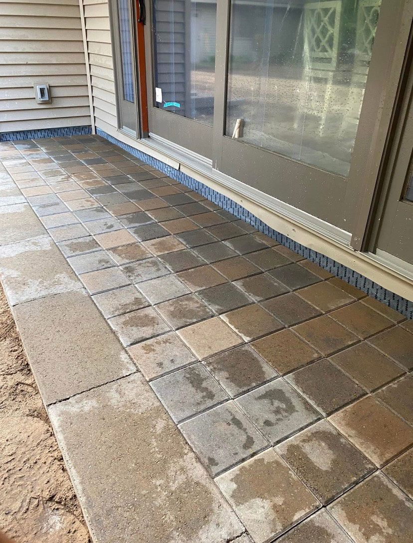 A brick walkway is being built in front of a house.