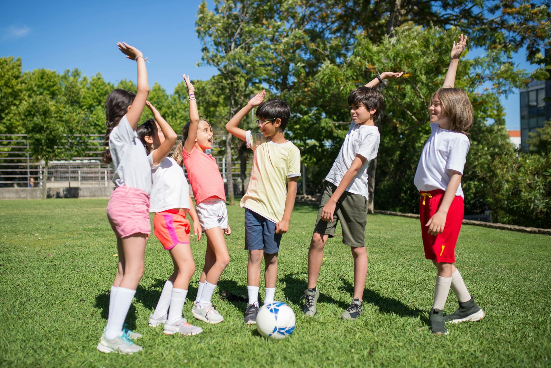 A group of children are playing with a soccer ball in a park.
