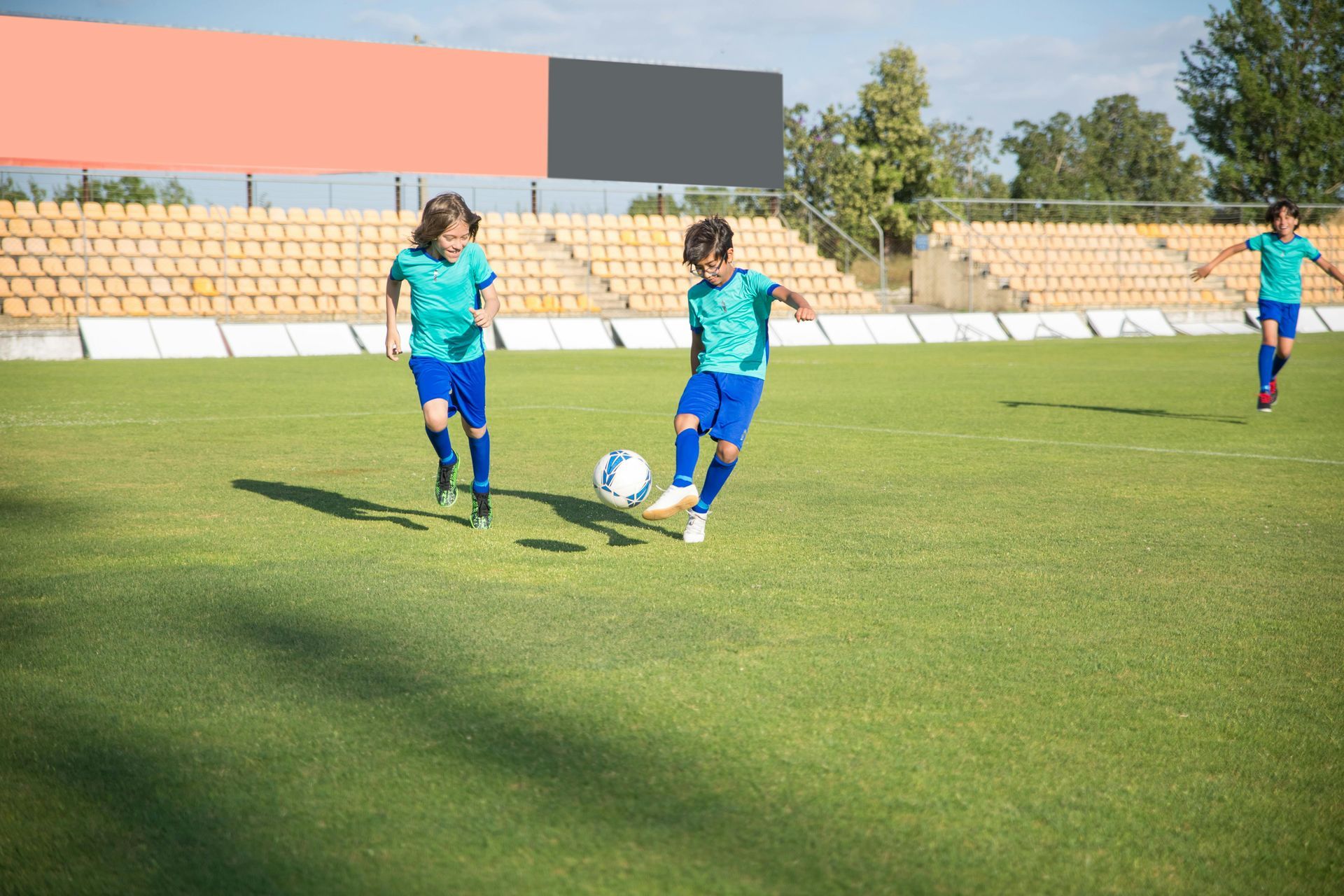 A group of young boys are playing soccer on a soccer field.