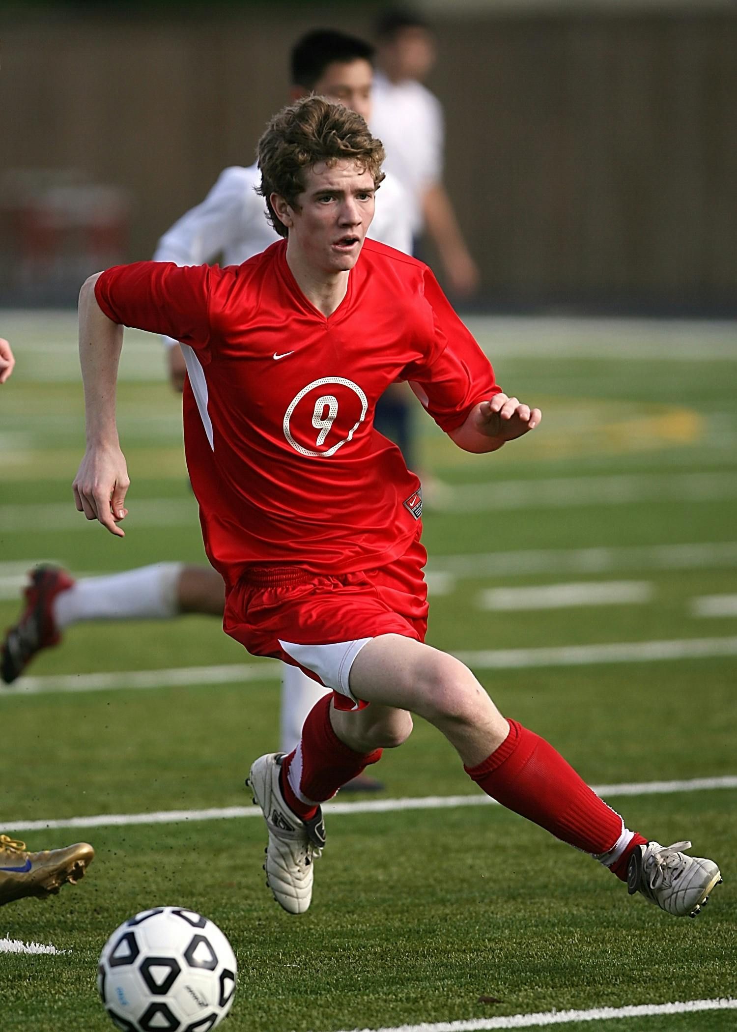 A soccer player wearing a red jersey with the number 9 on it