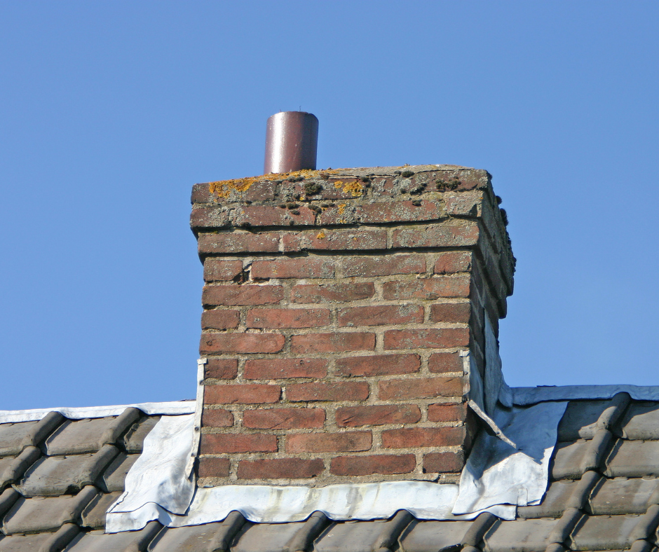 A brick chimney on top of a tiled roof