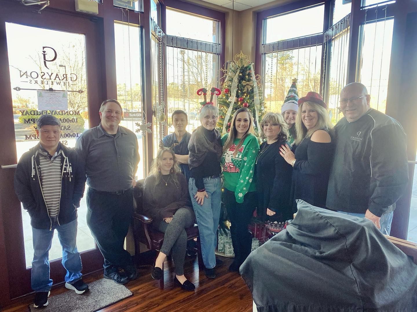 A group of people are posing for a picture in a barber shop.