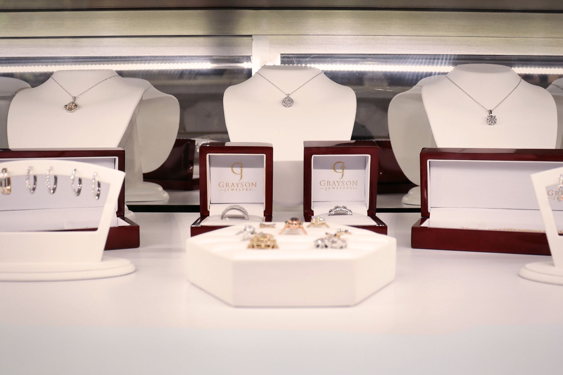 A display case filled with necklaces , earrings , and rings.