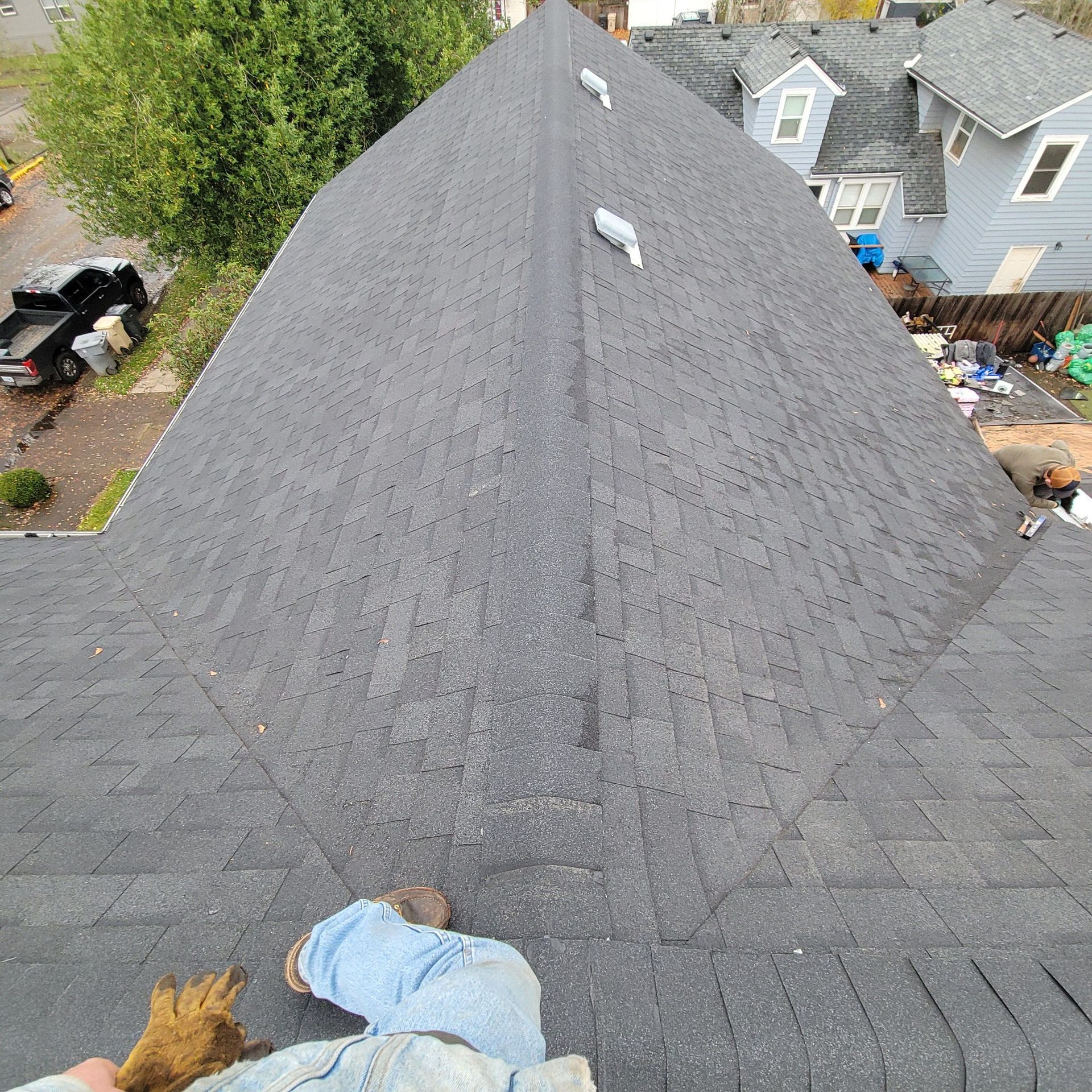 A person is standing on the roof of a house.