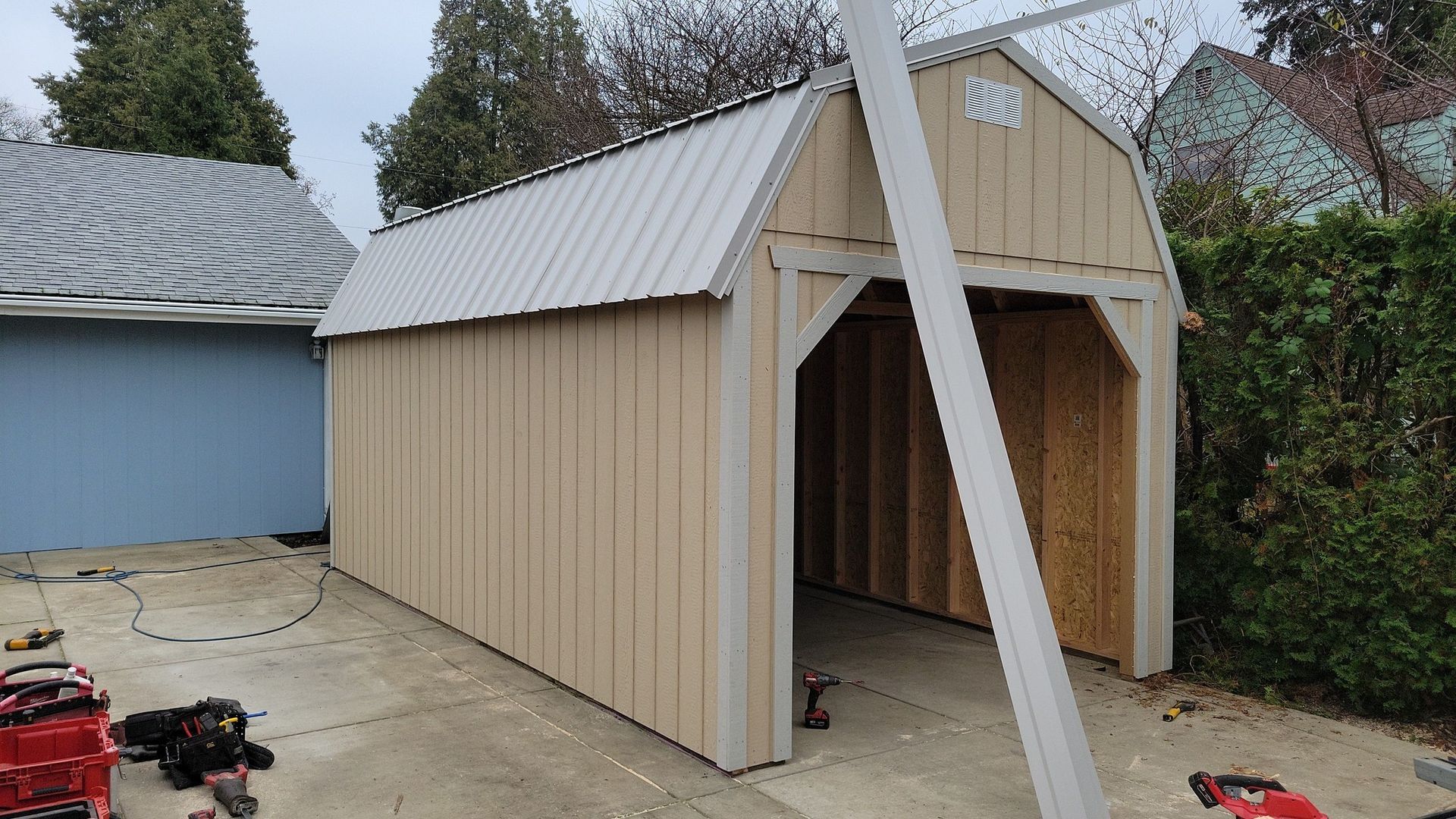 A garage is being built in a driveway next to a house.