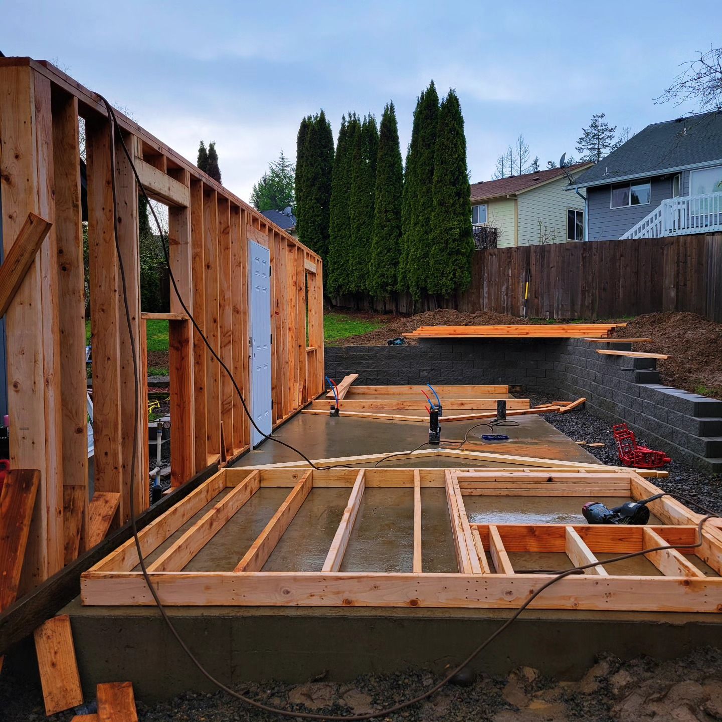 A wooden structure is being built in a backyard
