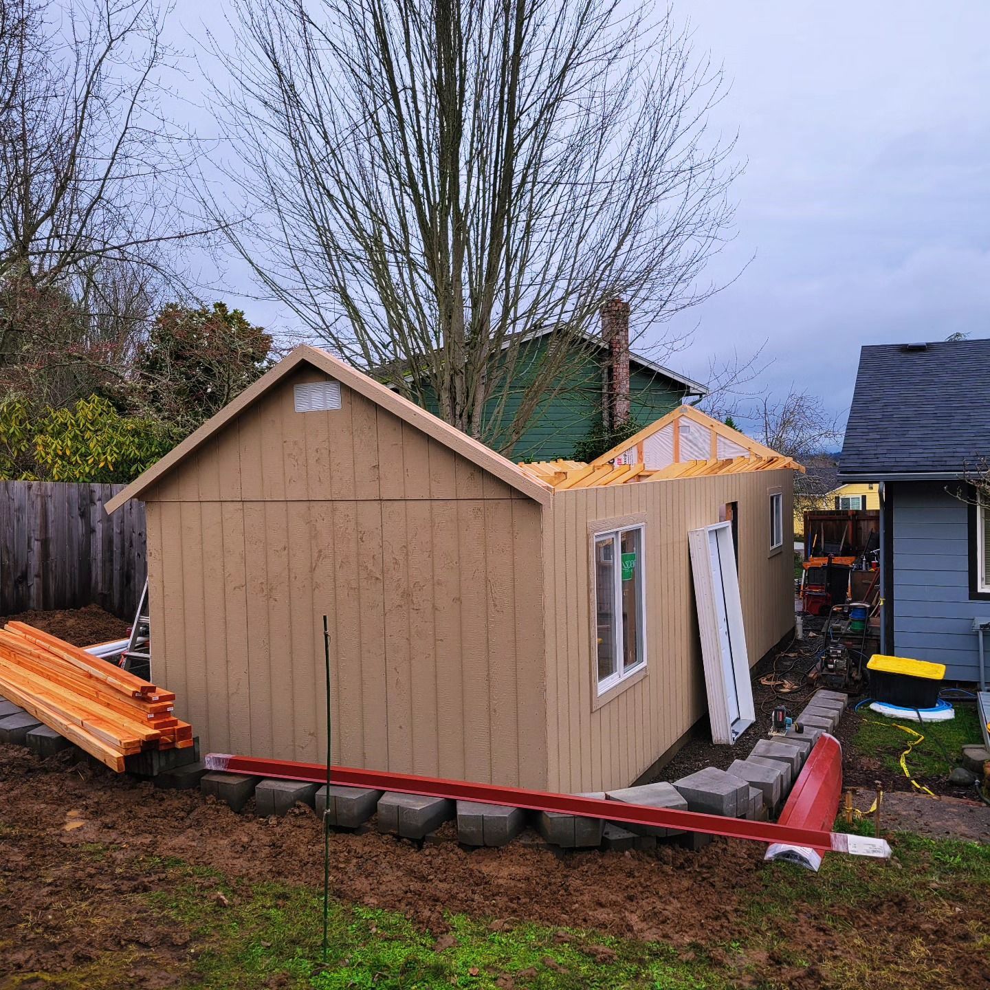 A shed is being built in the backyard of a house