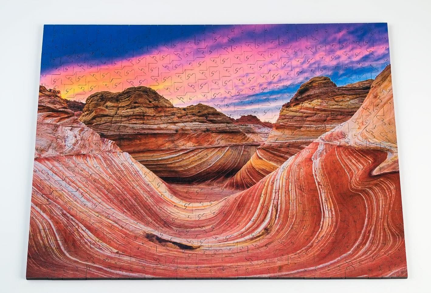 A painting of a canyon with a sunset in the background.