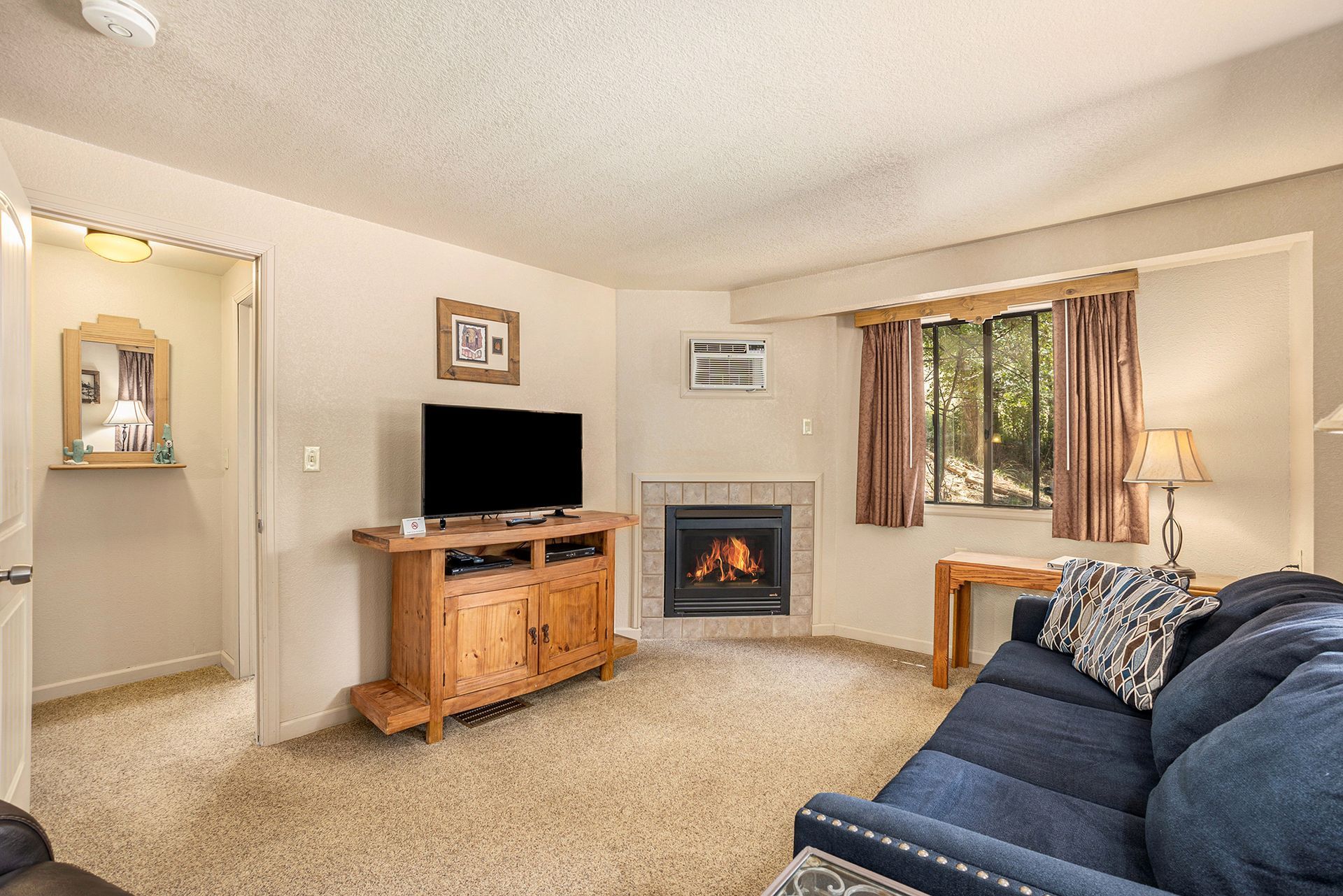 A living room with a couch , television and fireplace.