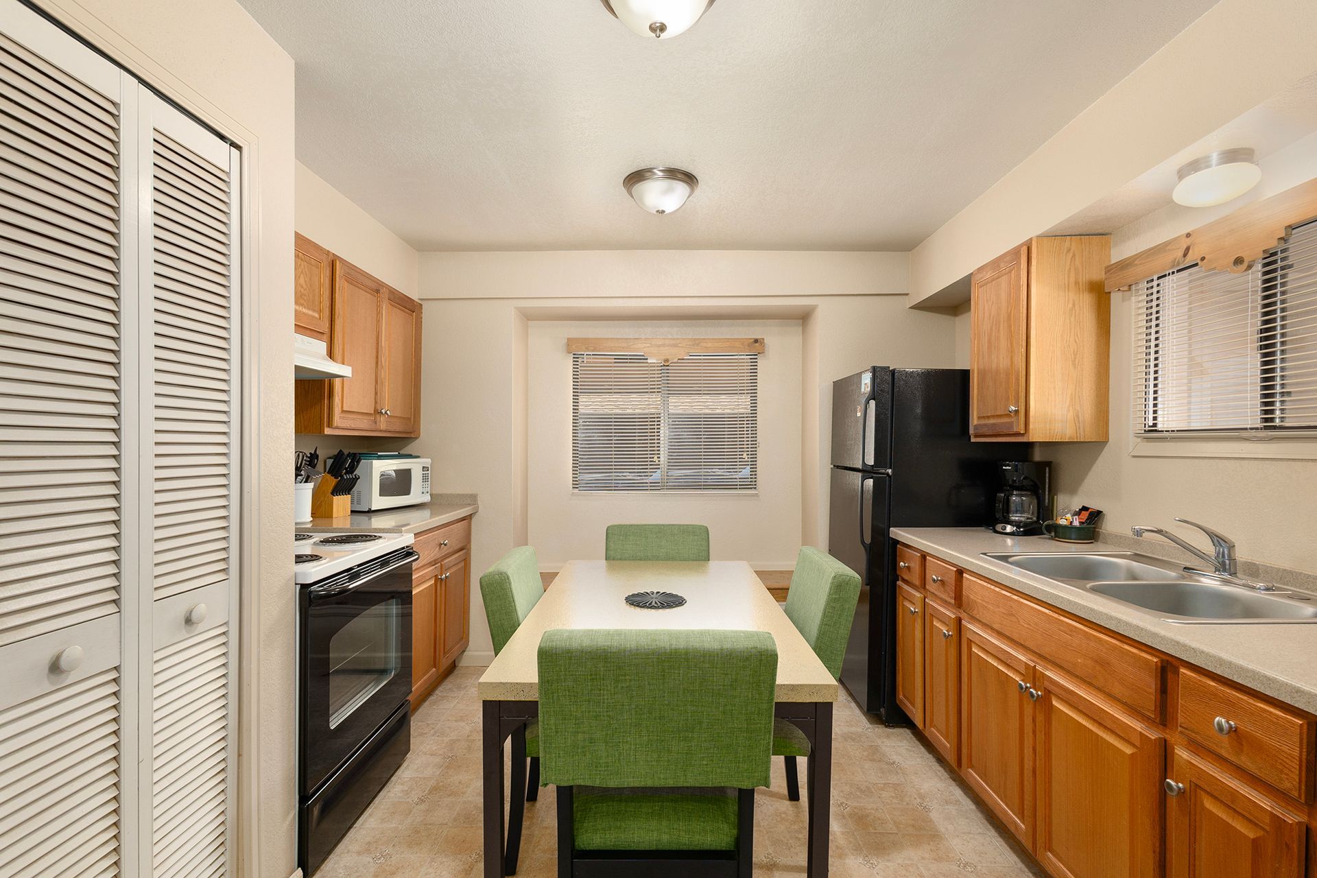 A kitchen with a table and chairs and a refrigerator