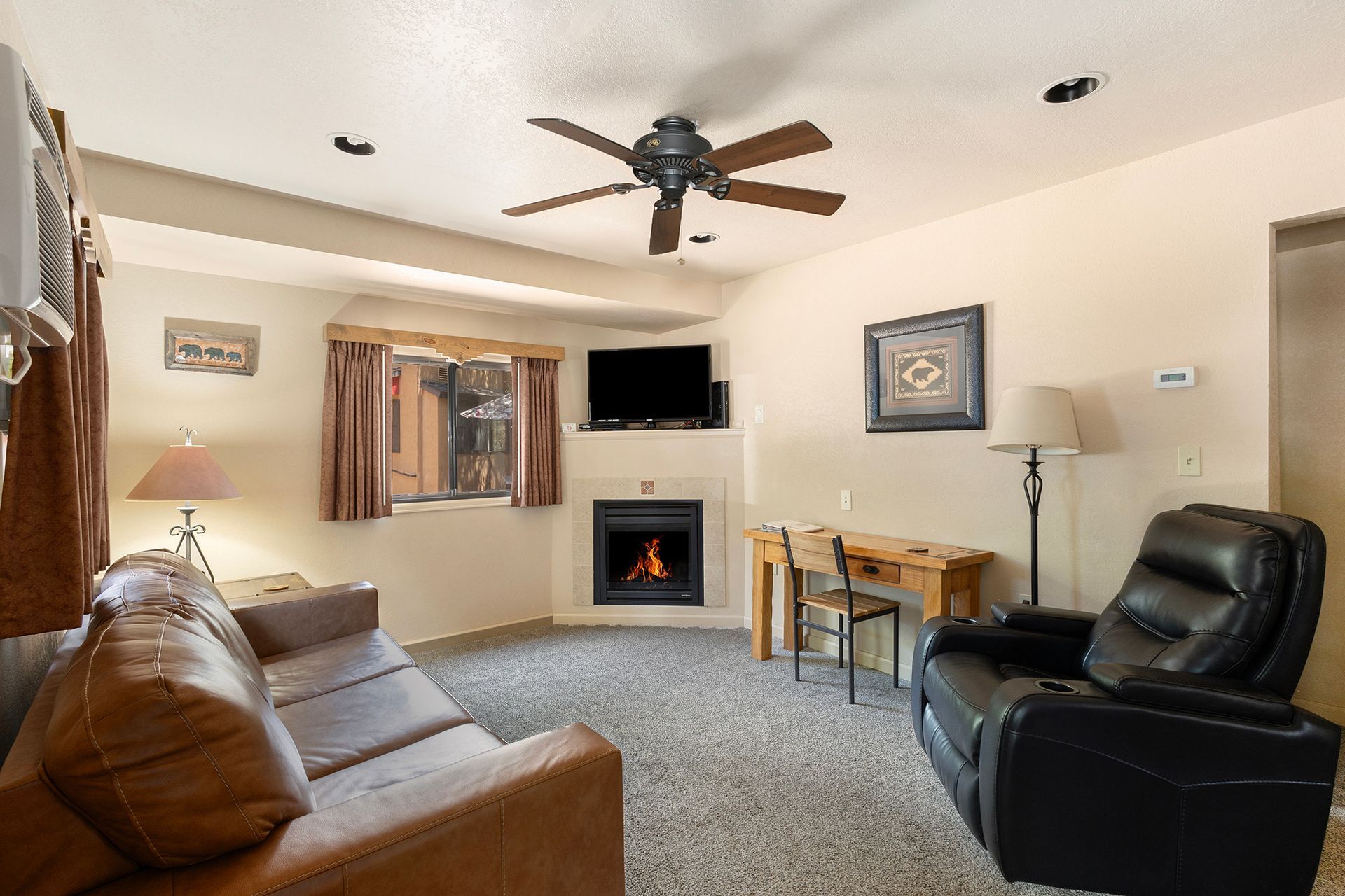 A living room with a couch , chair , television and fireplace.