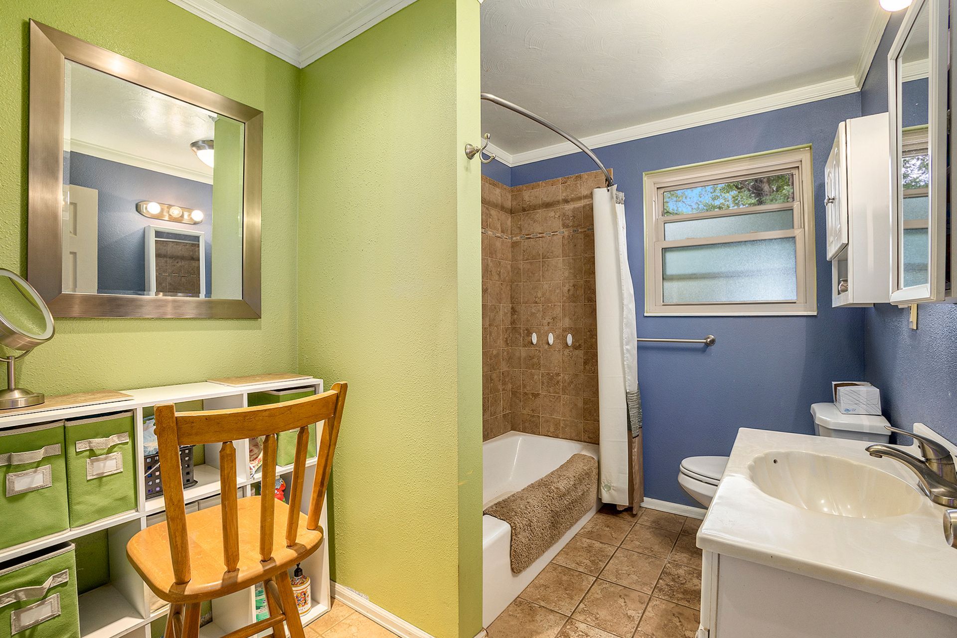 A bathroom with a sink , toilet , shower and mirror.